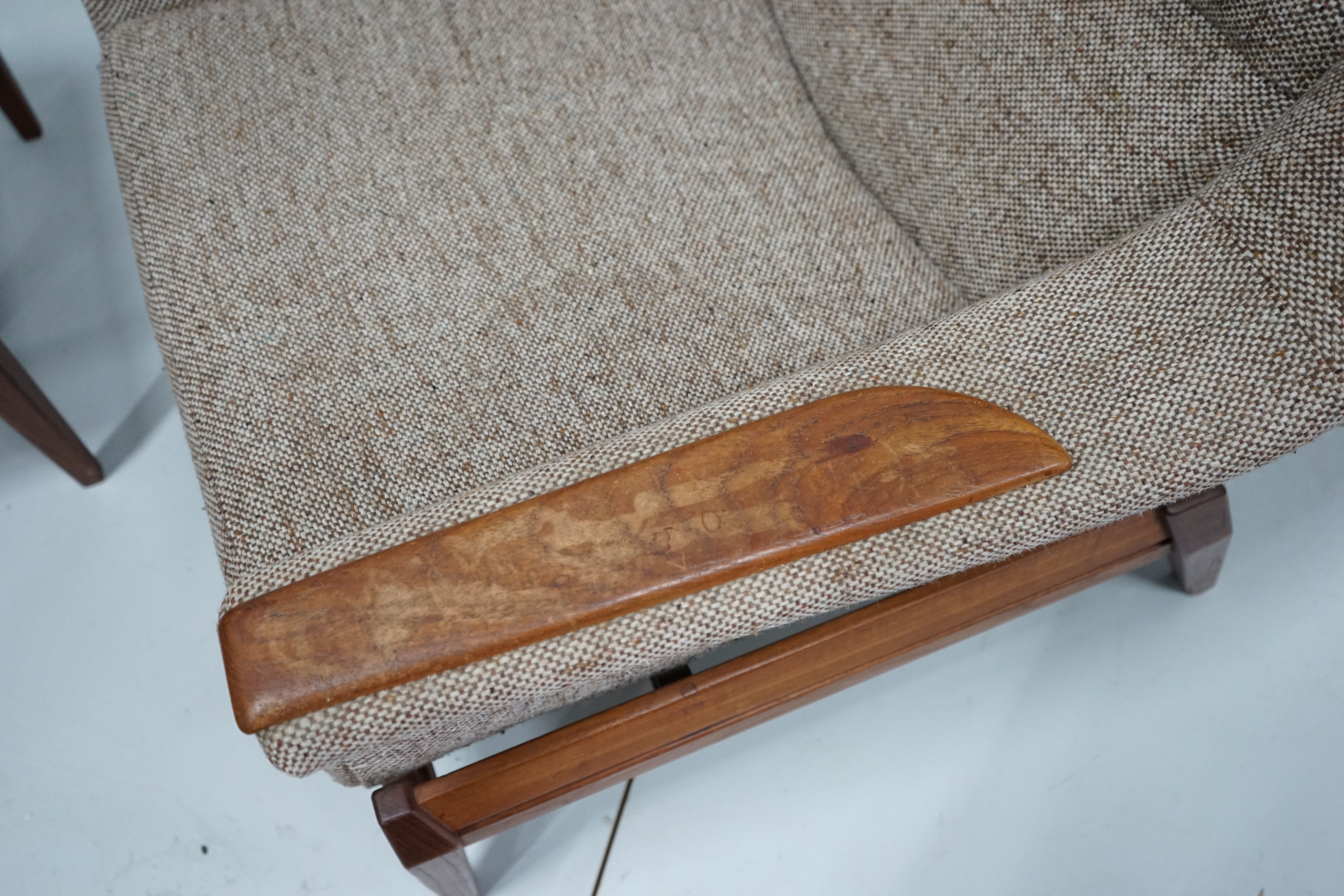 In the manner of Kofod Larsen, a mid century upholstered teak reclining armchair and adjustable foot stool, chair width 87cm, depth 86cm, height 102cm.